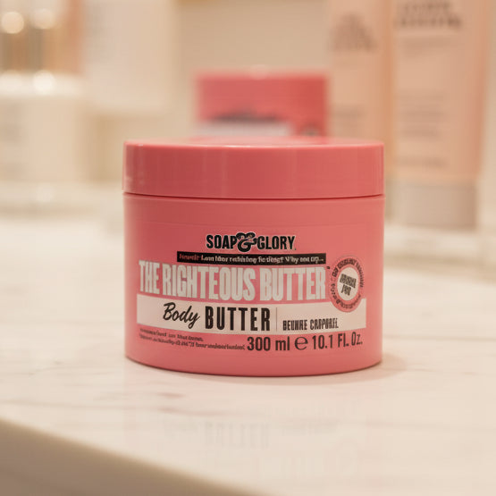 Pink jar of Soap & Glory The Righteous Butter Body Butter on a white textured background